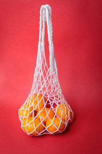 Eco-friendly mesh with tangerines on a red festive background. feast of the nativity of christ.