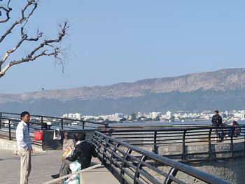 People on mountain against clear sky
