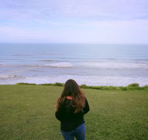 Rear view of woman looking at sea against sky