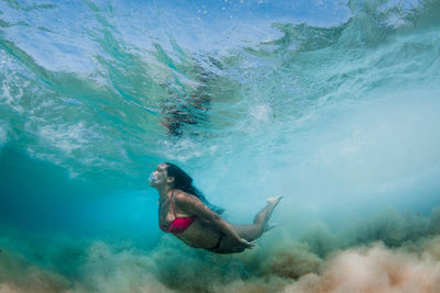Woman wearing bikini while swimming in sea