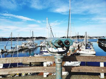 Sailboats moored at harbor