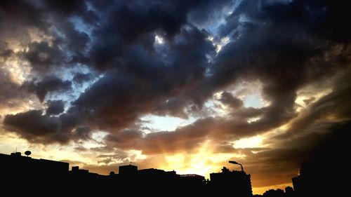 Silhouette of building against cloudy sky