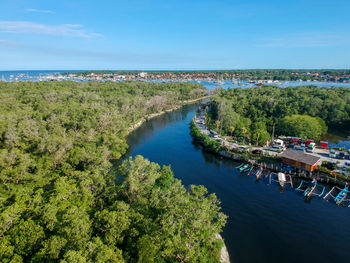 High angle view of sea, boats and trees against sky