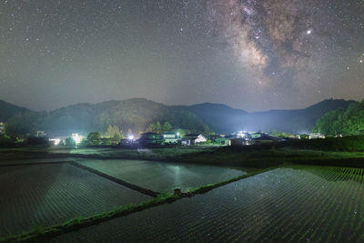 Scenic view of illuminated landscape against sky at night