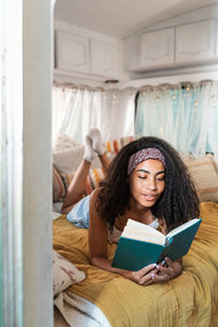 Young woman using phone while sitting at home