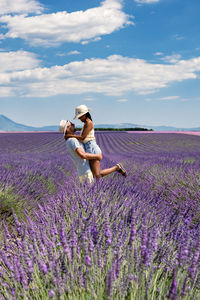 Rear view of woman with umbrella on field against sky