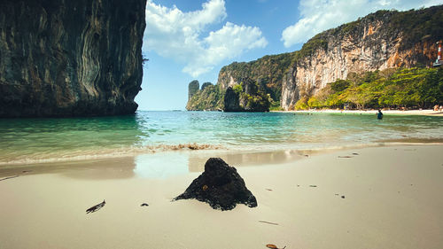 Rock formation on beach against sky