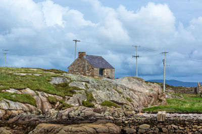 Built structure on rocks against sky