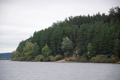 Scenic view of lake by trees against sky