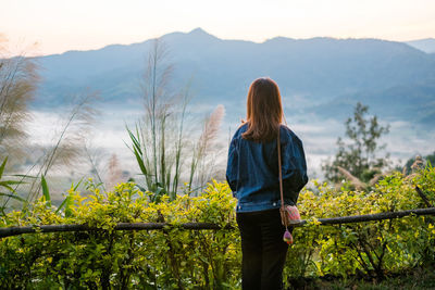 Rear view of woman looking at view of mountain range