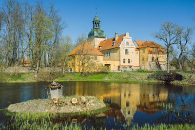 Reflection of trees and buildings on lake
