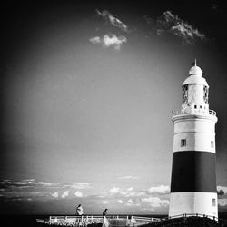 Lighthouse on sea against sky