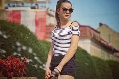 Beautiful young woman wearing sunglasses and shorts