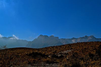 Scenic view of mountains against clear blue sky