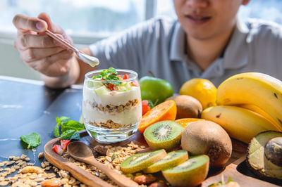 Midsection of woman holding ice cream on table