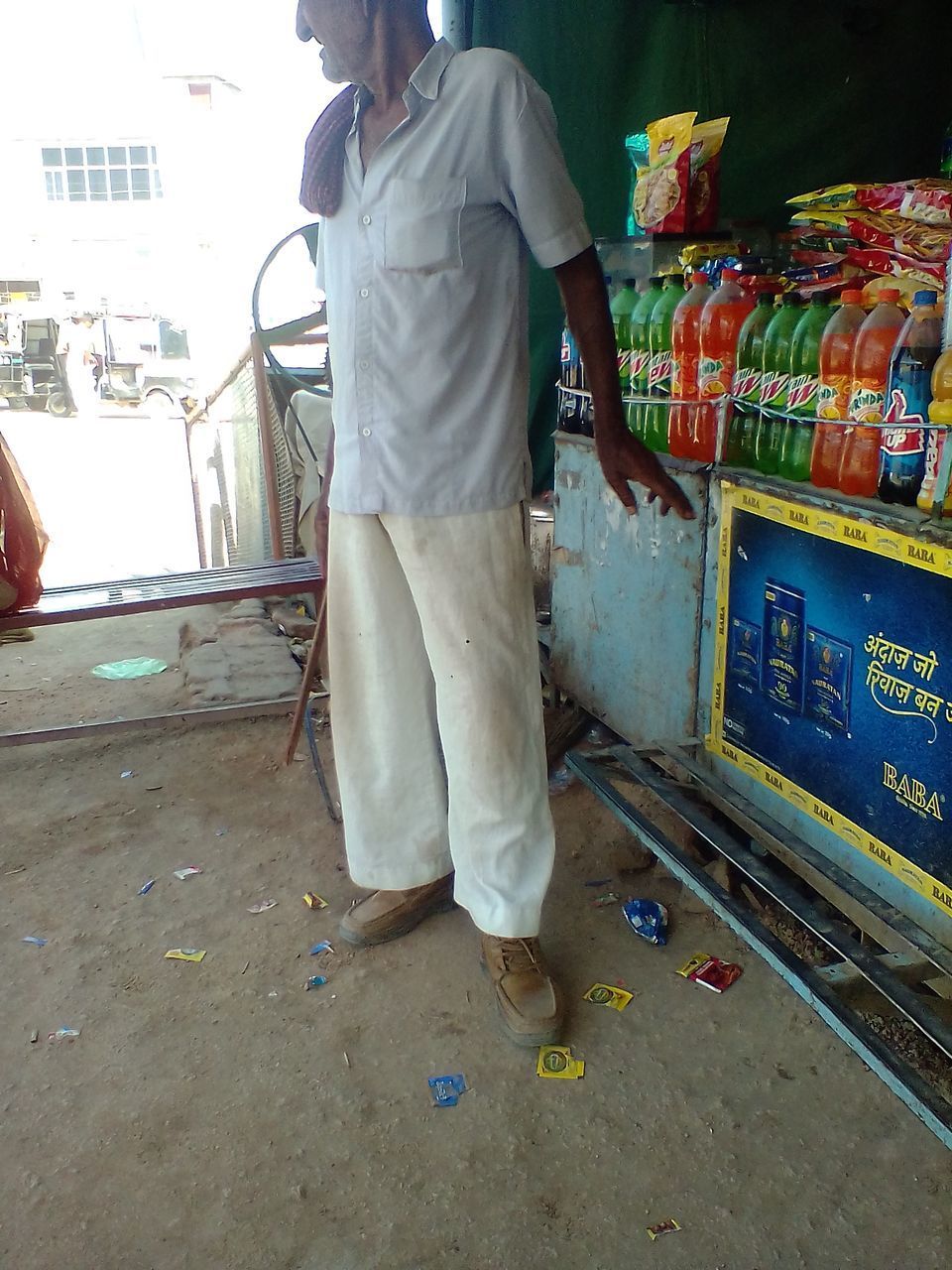 REAR VIEW OF MAN STANDING AT MARKET
