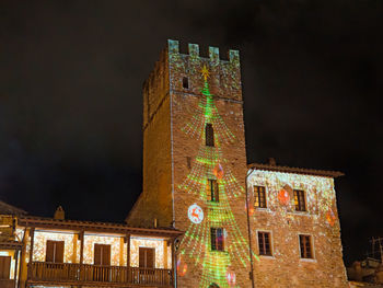 Low angle view of illuminated building against sky at night