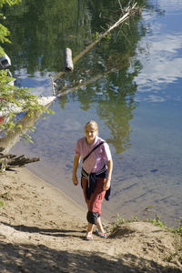 High angle portrait of young woman walking at lakeshore