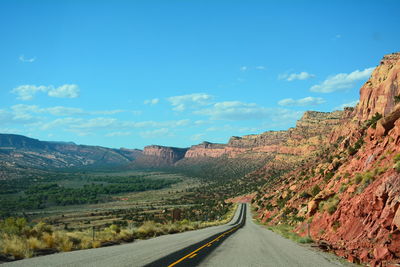 Road along canyon against blue sky