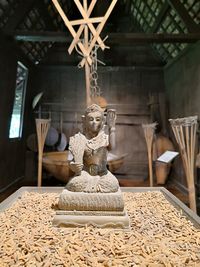 Close-up of goddess statue amidst grains on table