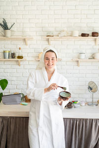 Portrait of a smiling young woman standing at home