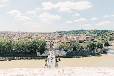 Scenic view of river by buildings against sky