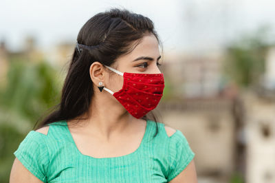 Close-up of woman wearing red mask