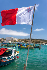 Boats moored on sea against sky