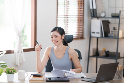 Young woman using laptop at office