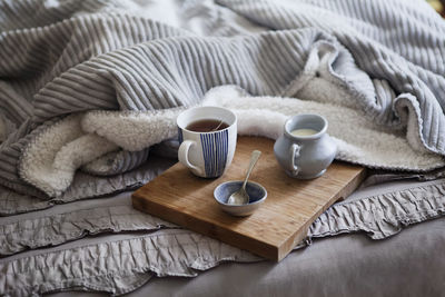 High angle view of tea with milk served on bed at home
