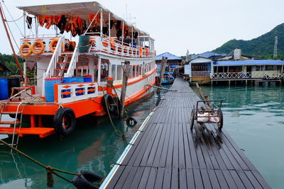 Boats moored at harbor against clear sky