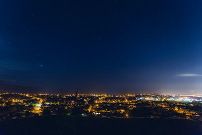 Illuminated cityscape against sky at night
