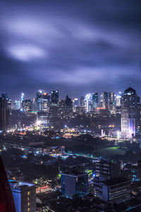 Illuminated cityscape against sky at night