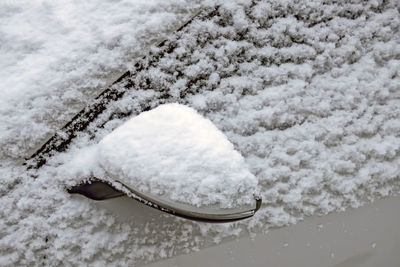 Snow covered car and rearview mirror