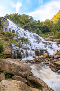 Scenic view of waterfall against sky