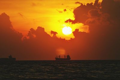 Silhouette boats on sea against sky during sunset