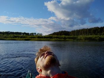 Man against lake in sunny day