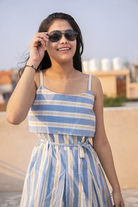 Young woman wearing sunglasses standing outdoors