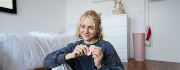 Portrait of smiling young woman standing at home