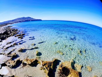 Scenic view of sea against clear blue sky