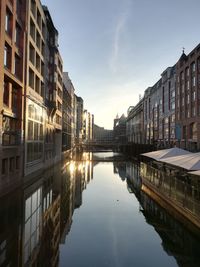 Canal amidst buildings in city against sky