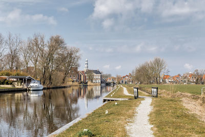 Bridge over river by buildings against sky