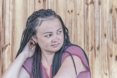 Close-up portrait of young asian beautiful woman, with dreadlocks on her black hair, looking away