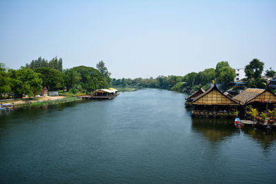 Scenic view of river by buildings against clear sky