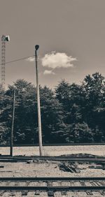 Railroad tracks by street against sky