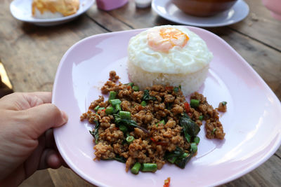 Close-up of hand holding food in plate