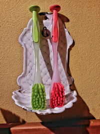 Close-up of toothbrushes hanging from wall in bathroom