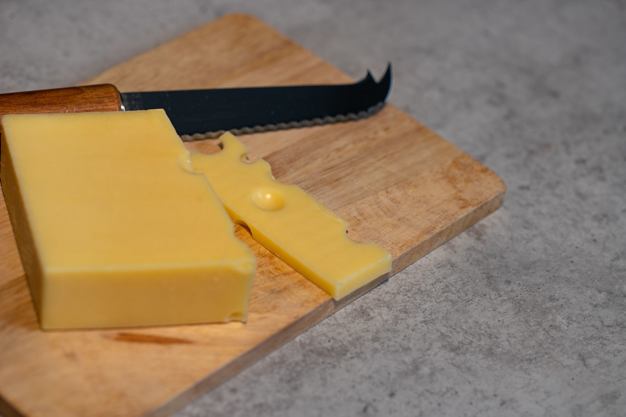 HIGH ANGLE VIEW OF YELLOW AND KNIFE ON TABLE