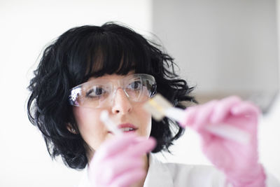 Young woman scientist portrait with gloves and safety glass