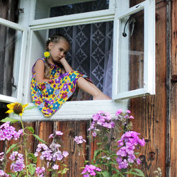 Side view of woman sitting by plants